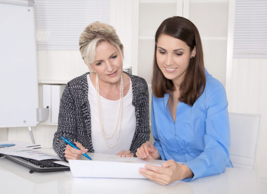 Two attractive business woman in meeting analyzing budget.